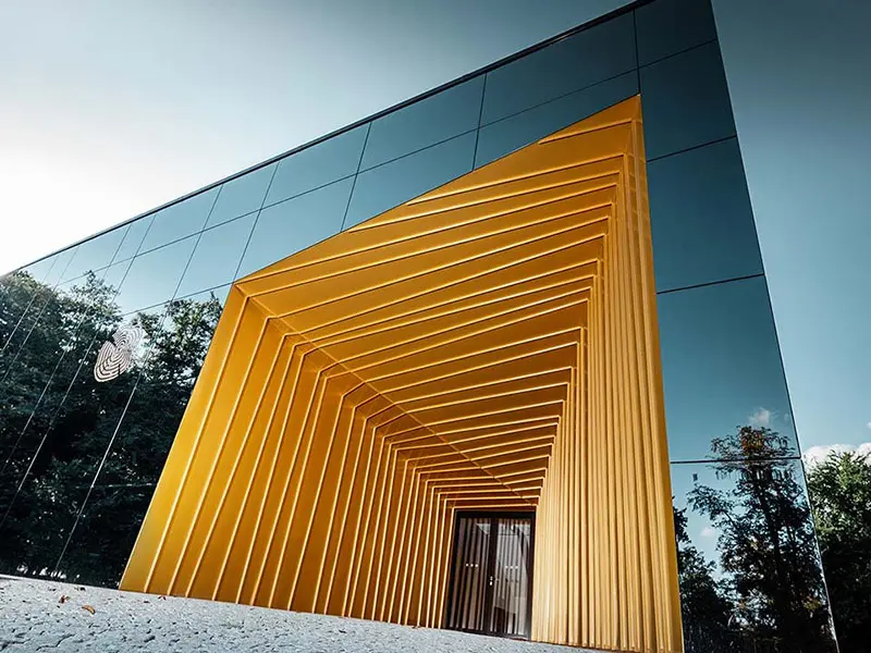 Château Rúbaň wagt die Sanierung mit Aluminium in gold und spiegelnden Fassadenflächen als modernen Zubau