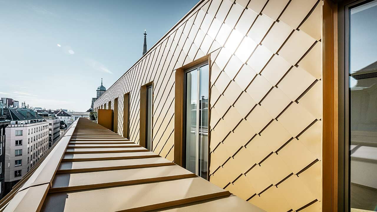 Fassadenbekleidung der Korb Etagen in Wien mit der PREFA Wandraute 29 × 29 in Perlgold.