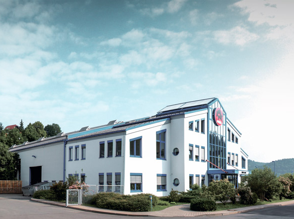 PREFA Firmengebäude mit blauen Fenstern und weißer Fassade in Wasungen, Deutschland.