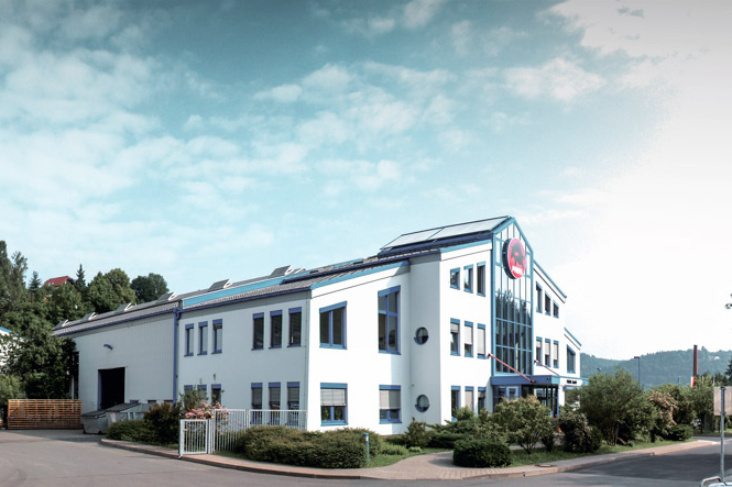 PREFA Firmengebäude mit blauen Fenstern und weißer Fassade in Wasungen, Deutschland.