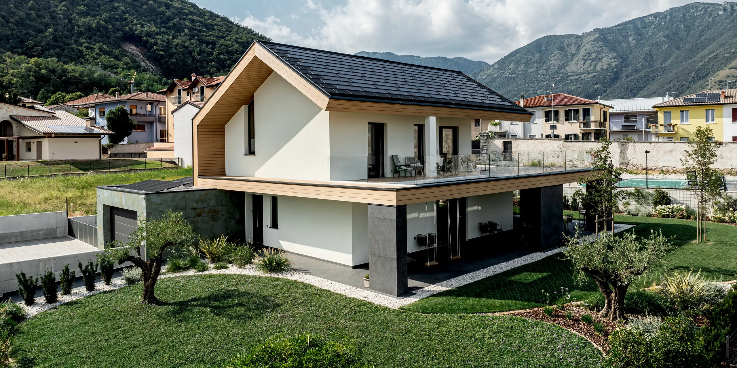 Zeitgemäßes Einfamilienhaus in Vicenza mit PREFA Dachplatte R.16 in elegantem P.10 Schwarz. Die präzise Aluminiumdeckung bildet einen stilvollen Kontrast zur hellen Fassade und der grünen Umgebung. Das langlebige PREFA Dach überzeugt durch hohe Widerstandsfähigkeit, geringes Gewicht und dauerhaften Schutz – eine verlässliche Lösung für anspruchsvolle Architektur.