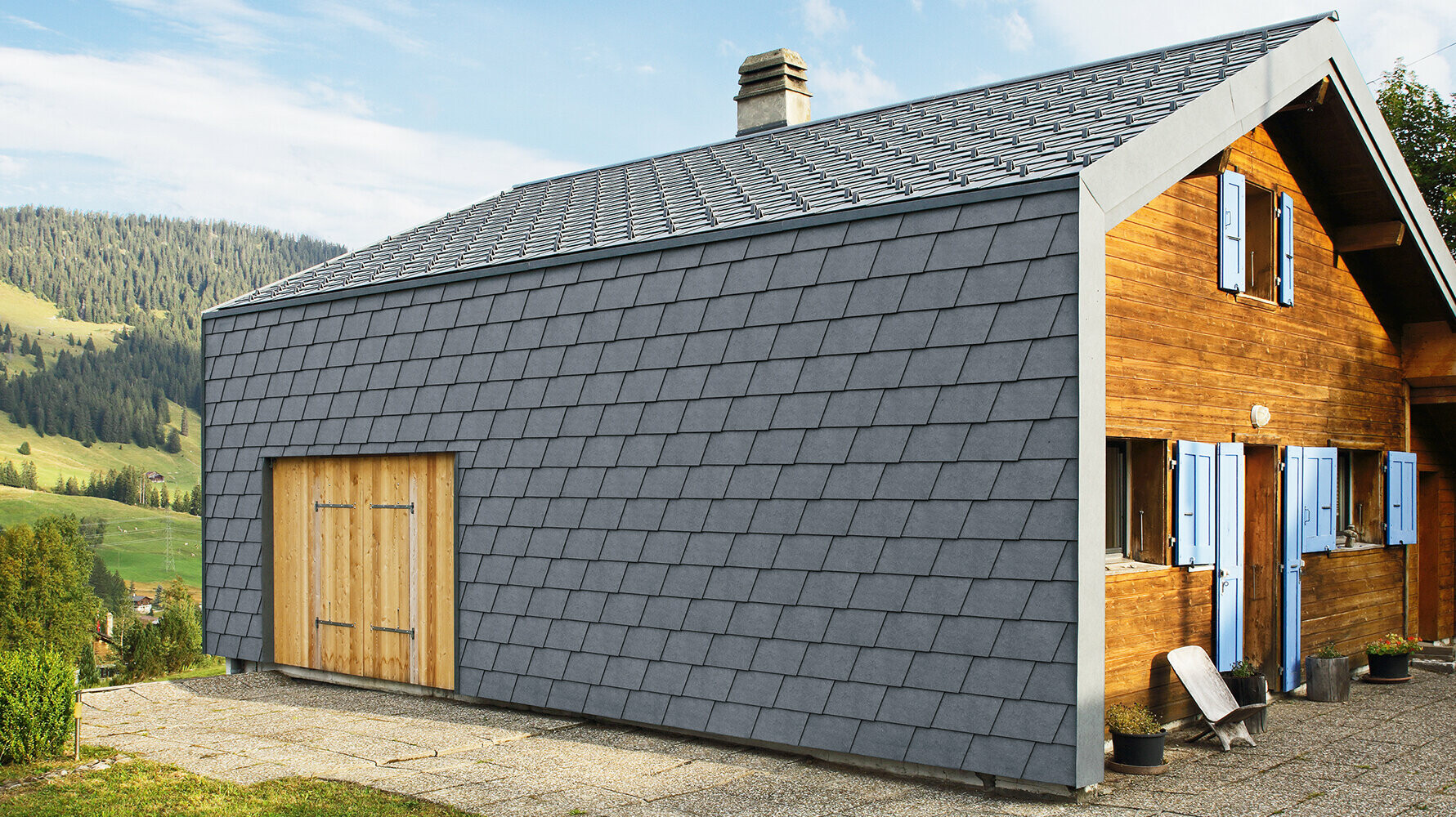 Modernes Einfamilienhaus verkleidet mit PREFA Wandschindeln in der Farbe P.10 Steingrau und Holzelementen.