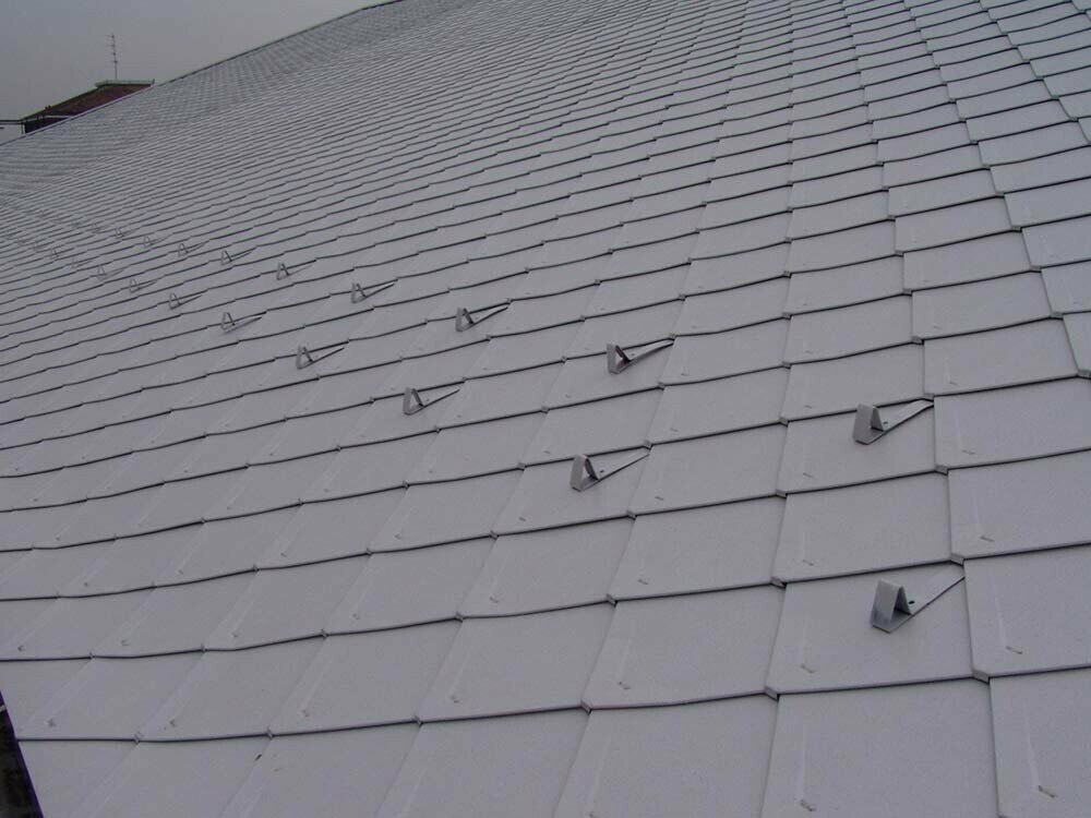 Dach einer denkmalgeschützten Eishalle nach der Sanierung mit PREFA Dachrauten in Weiß