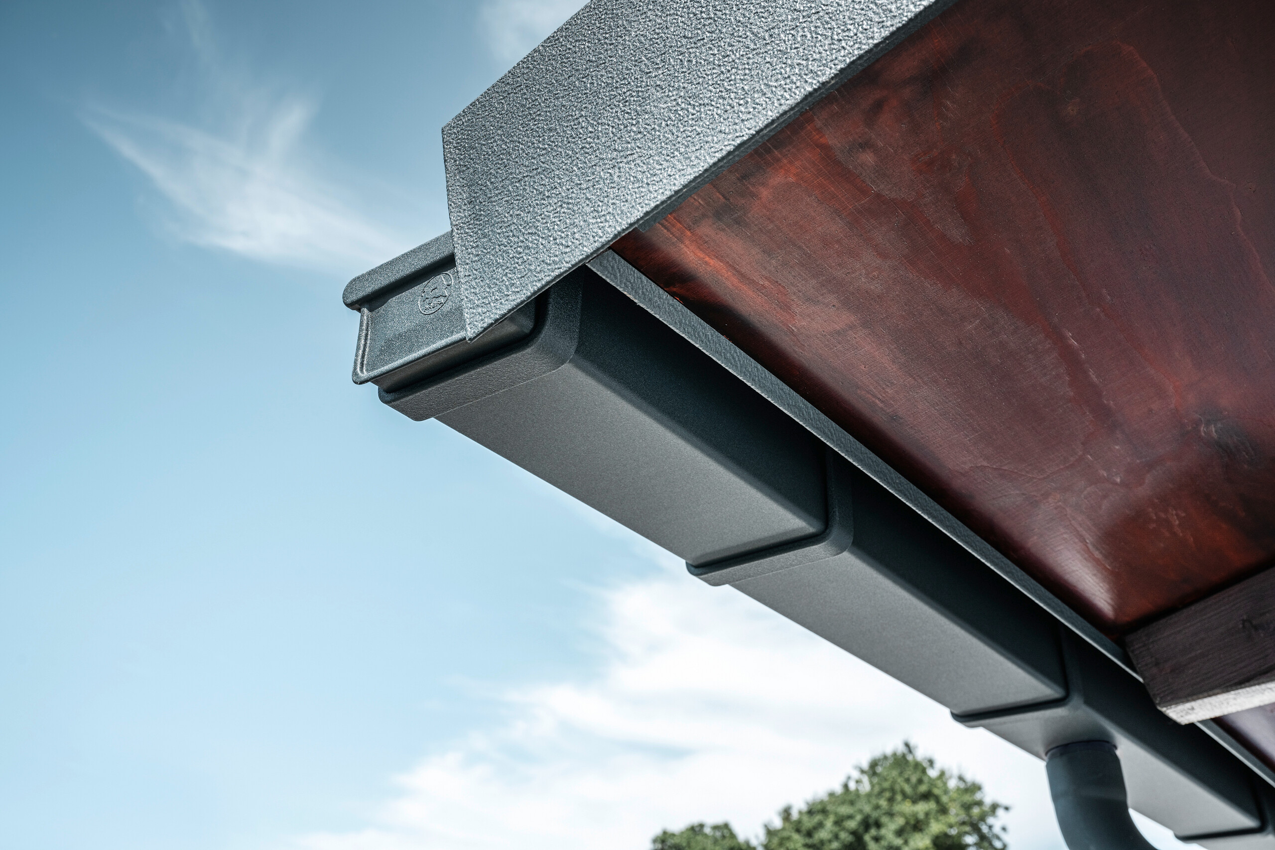 Detailaufnahme des PREFA Dachentwässerungssystems in P.10 Anthrazit am Dach eines Einfamilienhauses in Dortmund.