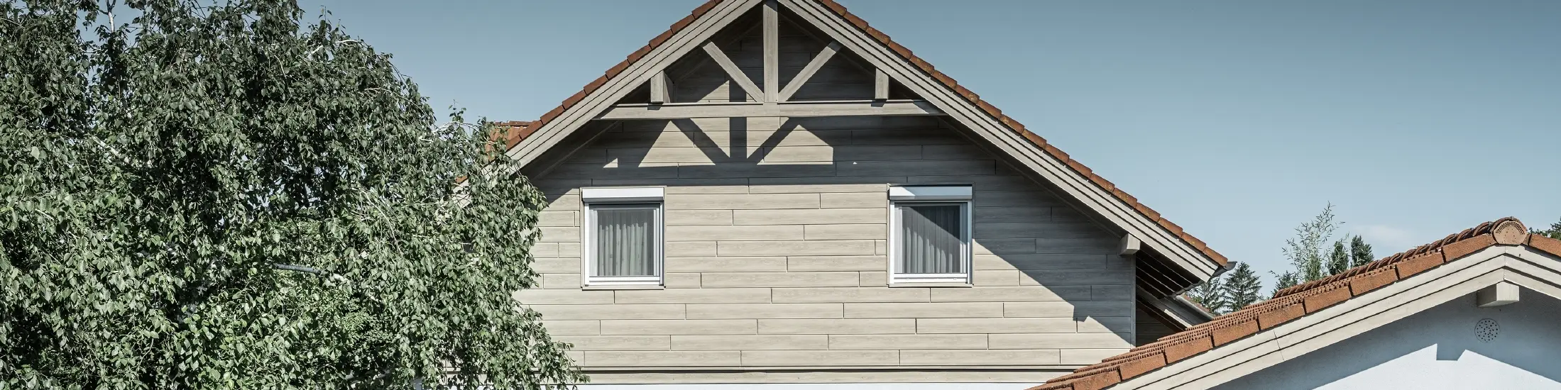 Die Aluminiumfassade in Holzoptik von PREFA wurde hier horizontal verlegt und muss nie mehr nachgestrichen werden.
