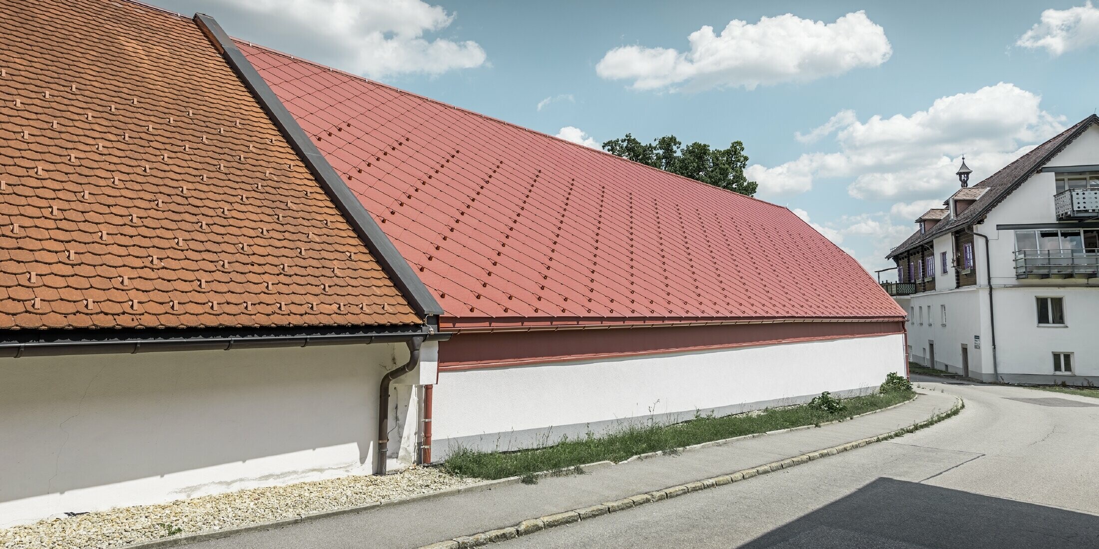 Außenaufnahme der Kerzenwelt in Schlägl; Das Dach wurde mit der großflächigen PREFA Alu-Raute 44x44 in Oxydrot eingedeckt.