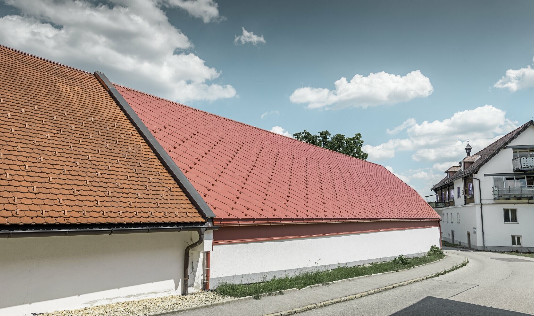 Außenaufnahme der Kerzenwelt in Schlägl; Das Dach wurde mit der großflächigen PREFA Alu-Raute 44x44 in Oxydrot eingedeckt.