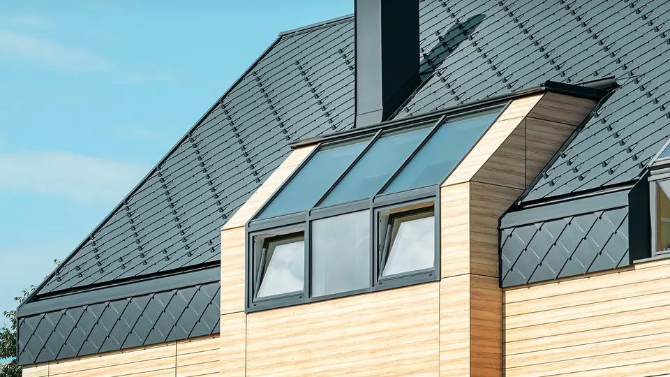 Einfamilienhaus mit Satteldach ohne Dachvorsprung mit einer Fassade in Holzoptik und einem Aluminiumdach in anthrazit