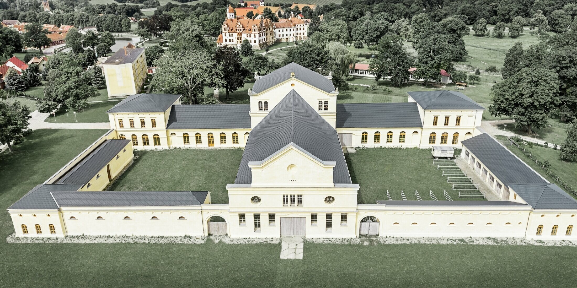 Aufnahme in der Vogelperspektive des Marstalls in Basedow; Das neu renovierte Schloss im Renaissancestil hat auch ein neues Dach mit der PREFA Dachschindel in Anthrazit.