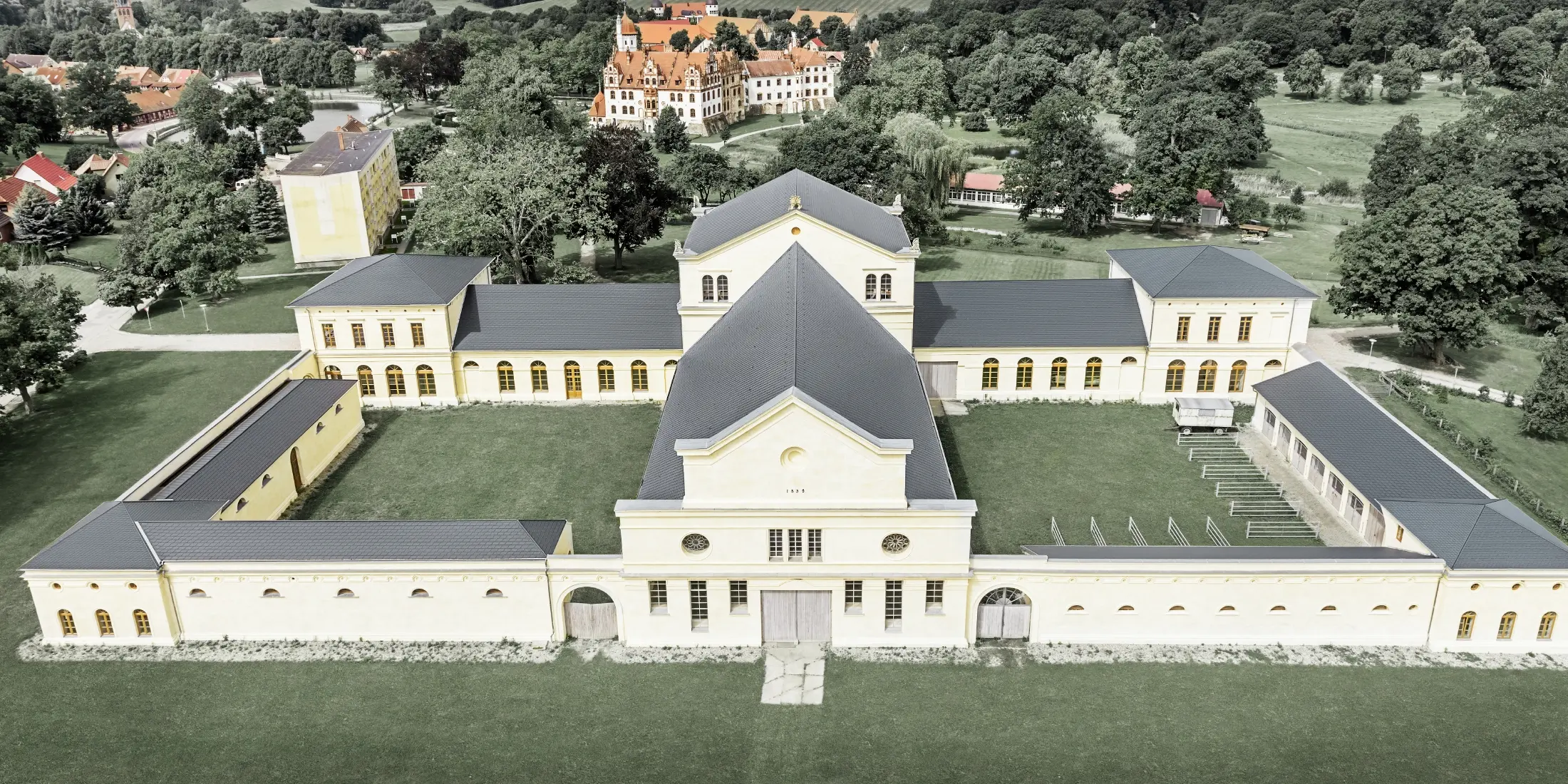 Aufnahme in der Vogelperspektive des Marstalls in Basedow; Das neu renovierte Schloss im Renaissancestil hat auch ein neues Dach mit der PREFA Dachschindel in Anthrazit.