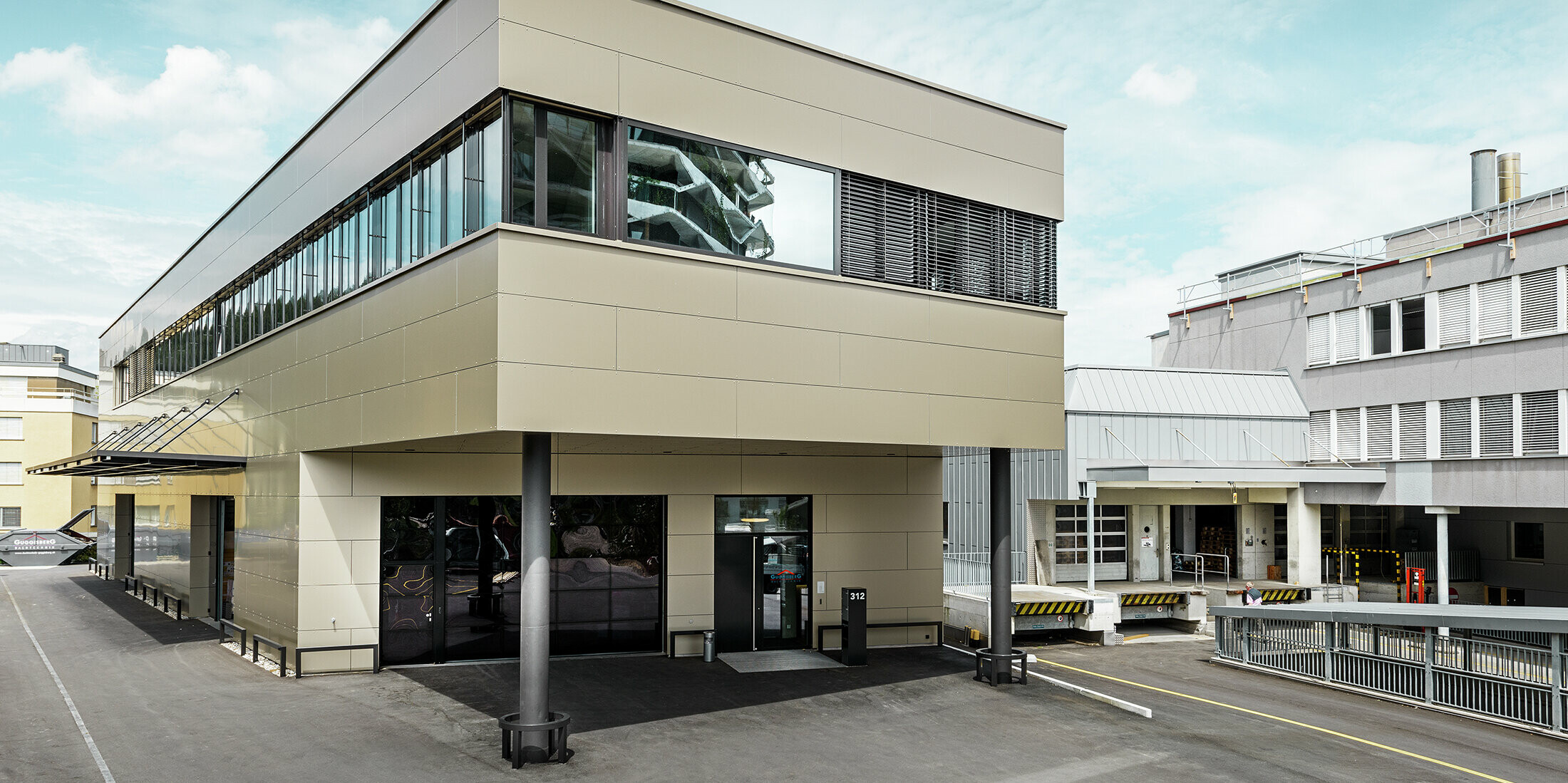 Moderner Zubau mit Werkstatt und Büro von Guggisberg Dachtechnik in Wabern (Schweiz). Die Gesamtansicht des Bürogebäudes betont die stilvolle PREFA Aluminiumfassade in Bronze. Die horizontal ausgerichtete Linienführung und das Flachdach unterstreichen die zeitgemäße Formensprache und die exklusive Materialwahl.