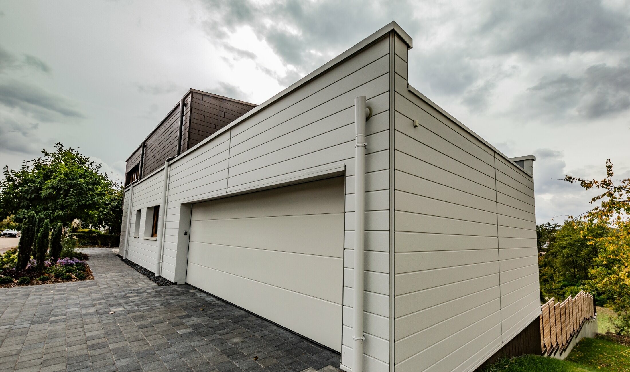 Garagenverkleidung mit den PREFA Siding in Weiß horizontal verlegt mit der PREFA Speiereinmündung.