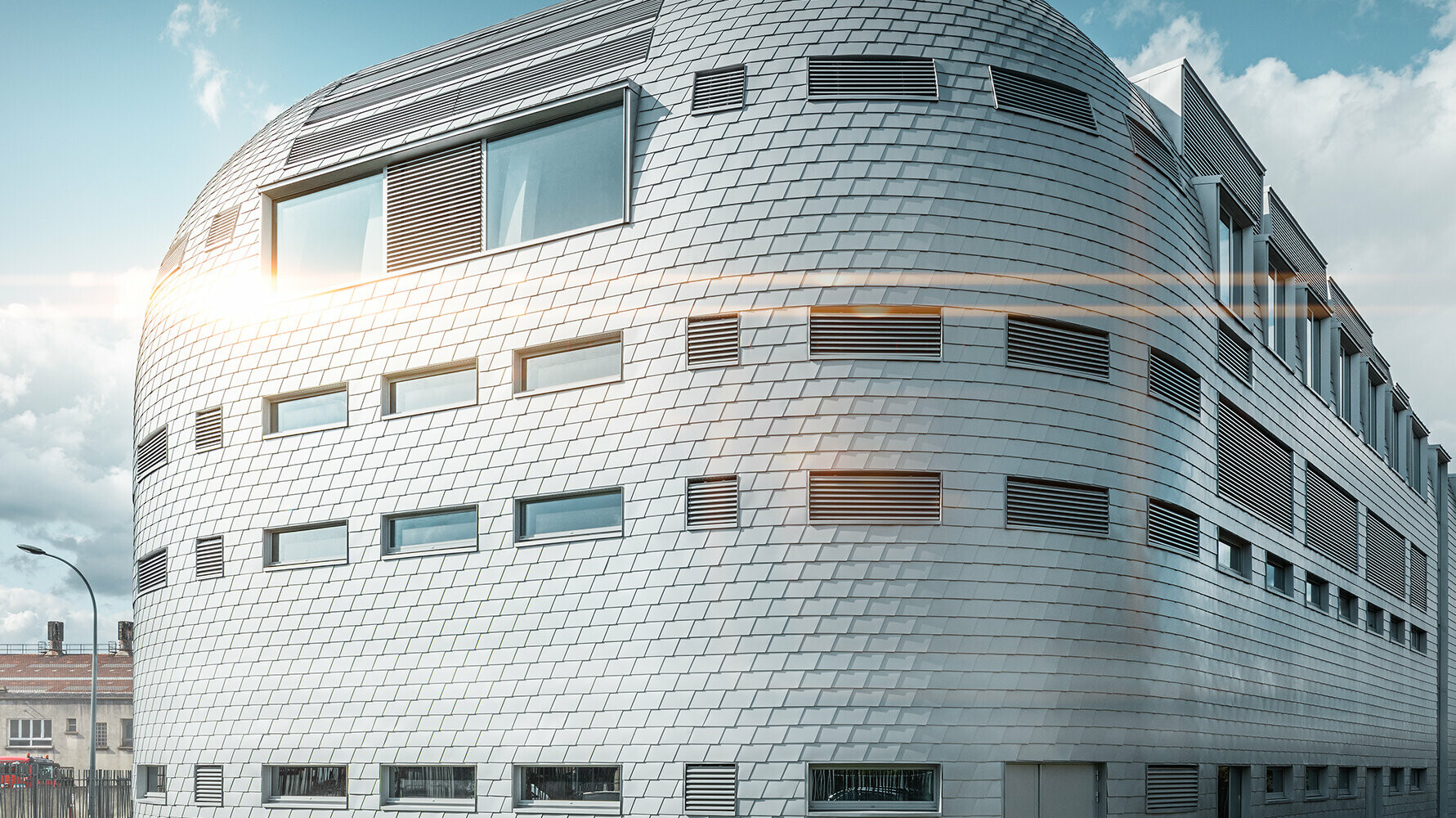 Abgerunde Gebäudefläche mit Aluminiumfassade von PREFA in der Farbe Silbermetallic