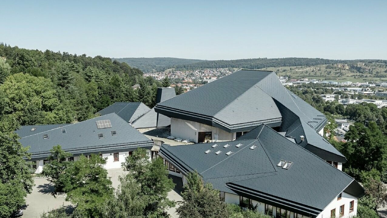 Verwinkelte Dachformen der Waldorfschule Heidenheim eingedeckt mit PREFA Dachschindeln in P.10 Anthrazit