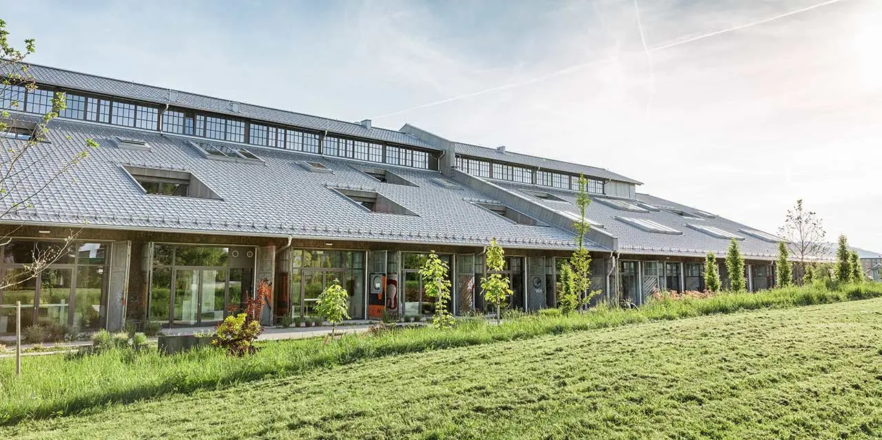 Die neu sanierte Panzerhalle in Salzburg mit vielen Geschäftslokalen und einem neuen PREFA Dach in Silbermetallic