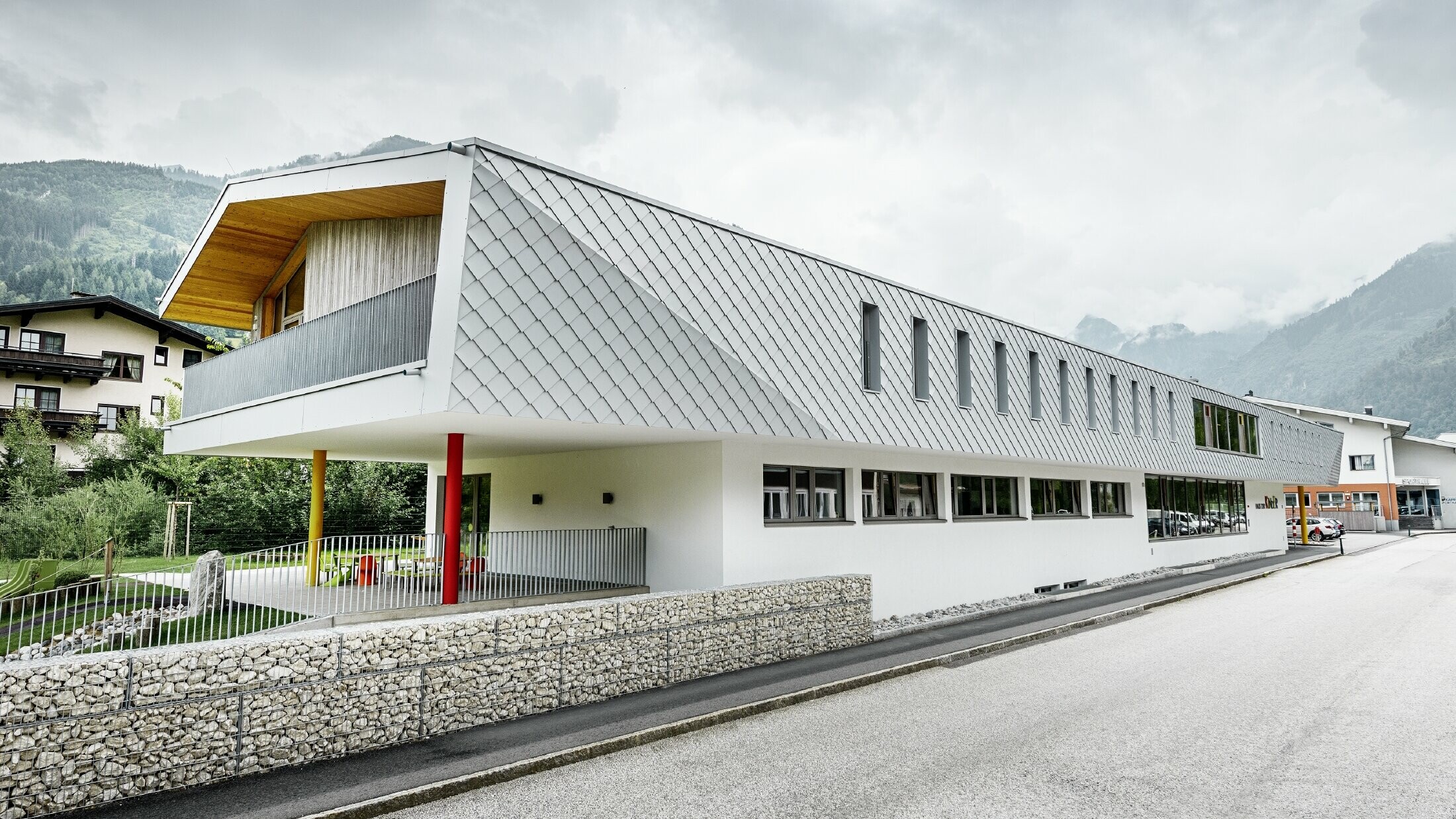 neu gebauter Kindergarten in Kaprun mit einer modernen Aluminium Fassade mit der PREFA Wandraute in prefaweiss