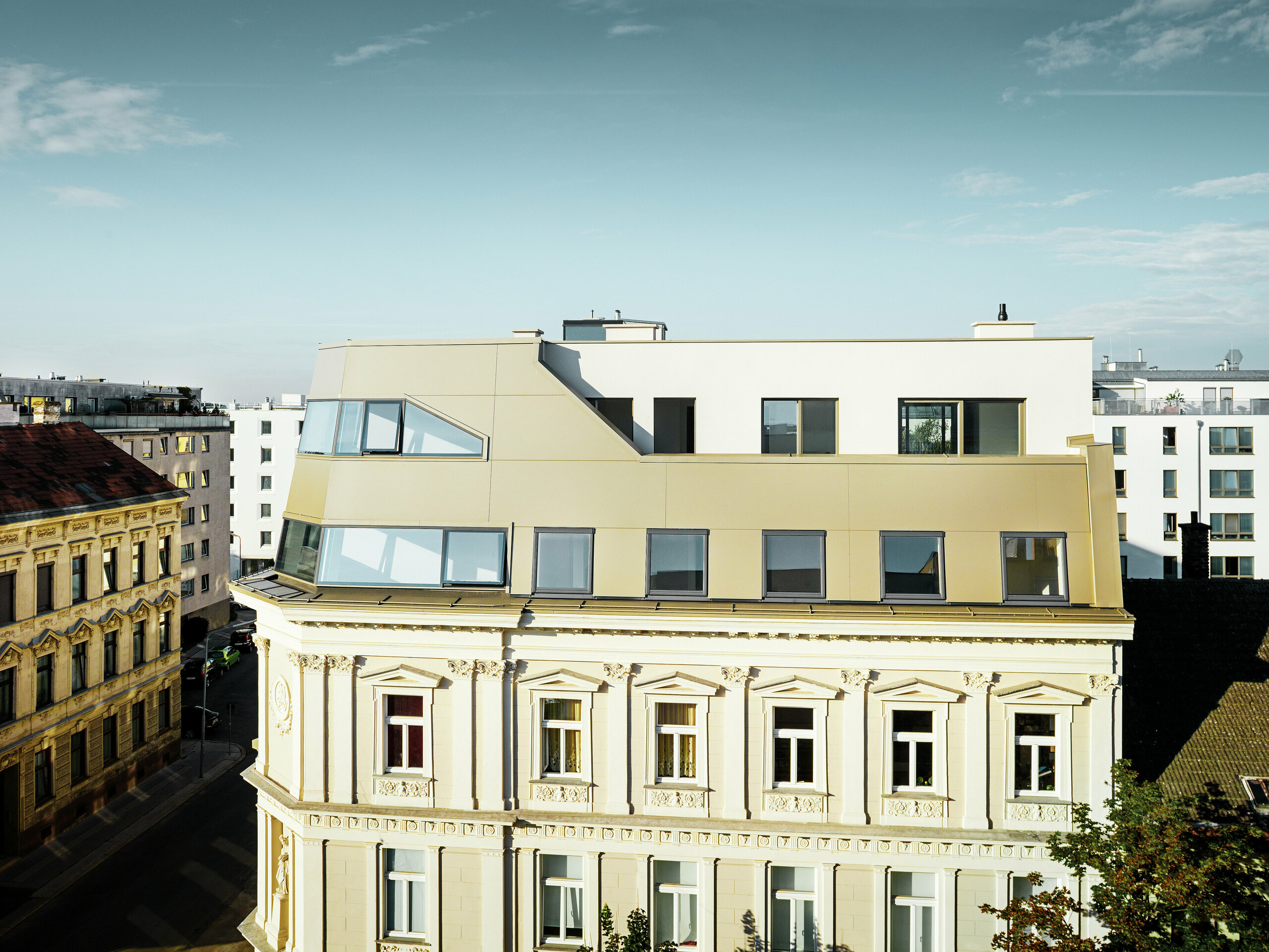 Das neue Dachgeschoss in der Schloßhofer Straße präsentiert sich mit PREFA Aluminium Verbundplatten in Bronze als architektonisch durchdachter Kontrast zum Altbau. Die Kombination aus Funktion, Ästhetik und Langlebigkeit steht für zeitgemäßes städtisches Wohnen. Die klar strukturierten Fensterachsen und die hochwertige Aluminiumfassade schaffen ein durchdachtes Zusammenspiel von Licht, Fläche und Funktionalität.