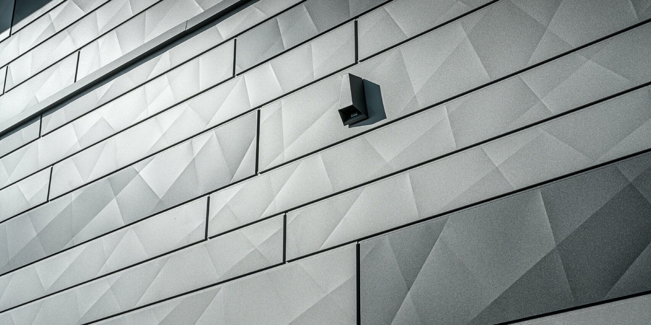 Detailansicht der Siding.X Fassadenpaneele in der Farbe P.10 Hellgrau und Anthrazit.