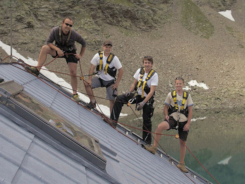 Das Team der Spengler am Dach der Flagger Schartenhütte in Südtirol; Sie verlegen die PREFA Dachplatte in Steingrau.