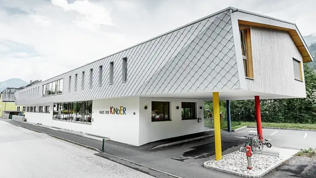 neu gebauter Kindergarten in Kaprun mit einer modernen Aluminium Fassade mit der PREFA Wandraute in prefaweiss